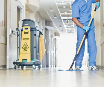 janitor sweeping a hospital hallway
